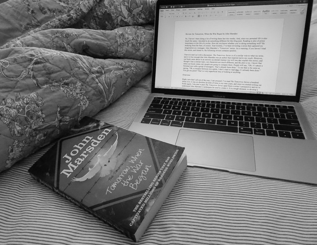 Picture of laptop editing review of book titled Tomorrow When the War Began. The book is closed and sitting beside the laptop and a blanket 