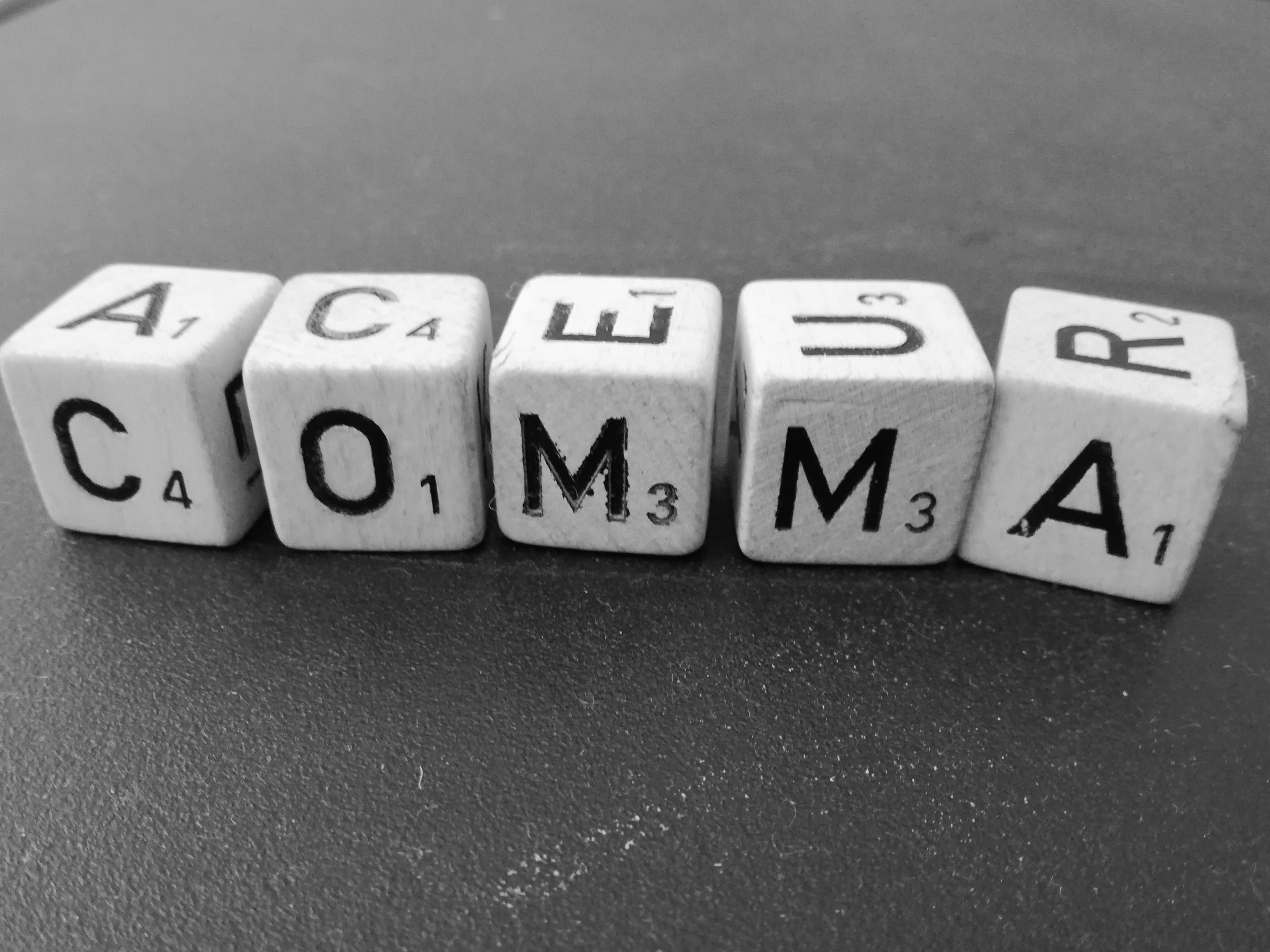 Grammarly. It has no problem telling us where there might be a misplaced comma, or even misplaced words. Picture of boggle blocks spelling out the word comma in black and white.